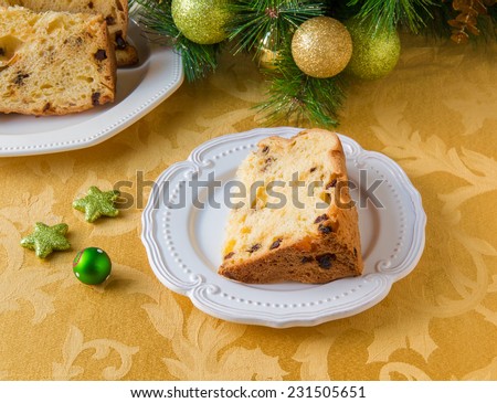 Christmas cake panettone on a plate and Christmas decorations.