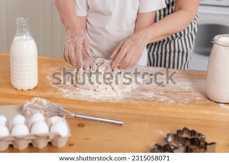 Happy family in kitchen. Grandmother granddaughter child hands knead dough on kitchen table together. Grandma teaching kid girl cook bake cookies. Household teamwork helping family generations concept Royalty-Free Stock Photo #2315058071