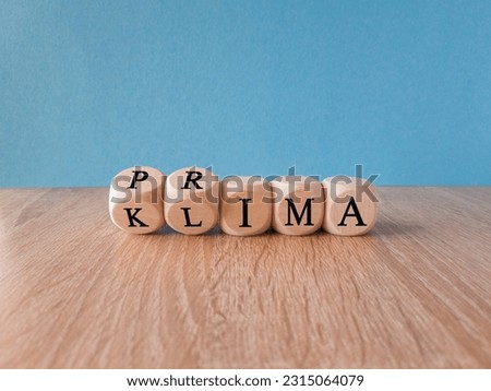 Dice form the German words 'Prima Klima' which can be translated by 'nice climate'. Beautiful blue background, copy space.
