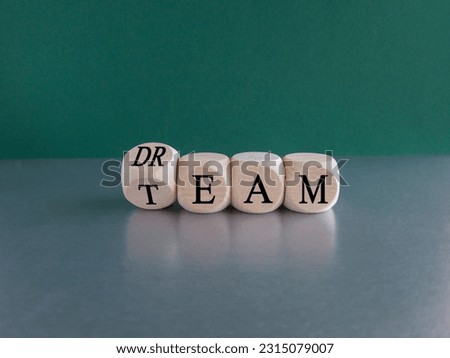 Dream team symbol. Turned wooden cube and changes the word Dream to Team. Beautiful grey table green background. Business and dream team concept, copy space. Royalty-Free Stock Photo #2315079007