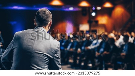 Speaker giving a talk on corporate business conference. Unrecognizable people in audience at conference hall. Business and Entrepreneurship event. Royalty-Free Stock Photo #2315079275