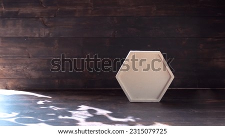 White polygon concrete podium on old wooden background with shadow for cosmetic products and presentation. Product display.