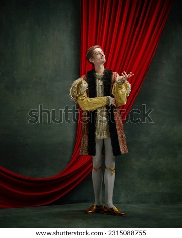 Portrait of young man, royal person, prince in retro clothes standing with noble, thoughtful look over dark green, vintage background. Concept of comparison of eras, history, renaissance art, remake Royalty-Free Stock Photo #2315088755