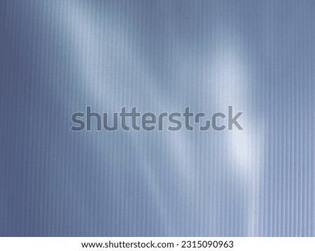 White light reflecting on striped plastic sheet for minimalist abstract background.