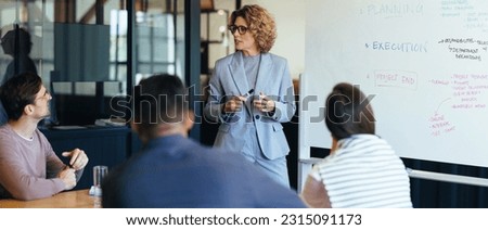 Project manager having a discussion with her team in a meeting. Business woman giving a presentation in an office boardroom. Team of professionals working together on a project.