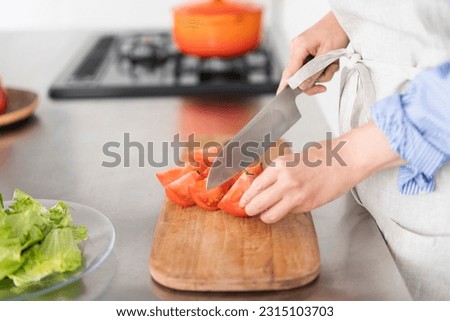 Closer picture of a woman cutting tomatoes