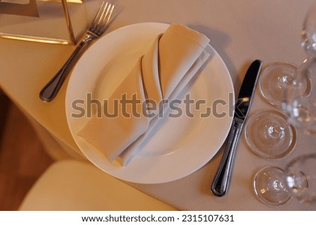 A set of dishes in light pastel colors: a plate, a napkin and cutlery. View from above. High quality photo