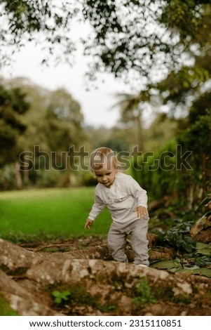 Adorable toddler girl, dressed comfortably for a day outdoors, joyfully exploring a park and discovering the beauty of the natural surroundings. Child walking in the park outdoor recreation