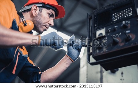 Skilled mechanical technicians tighten, loosen components with screwdriver to perform safety maintenance including corrections and modifications on machines to ensure it remains in standard condition Royalty-Free Stock Photo #2315113197
