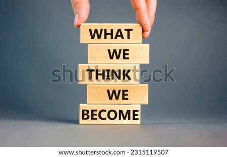 We become or think symbol. Concept word What we think We become on wooden block. Beautiful grey table grey background. Businessman hand. Business we become or think concept. Copy space.