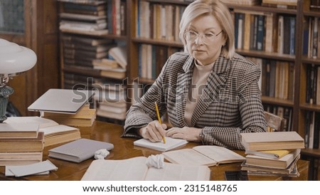 Woman novelist suffering from a lack of inspiration, sitting at her home library Royalty-Free Stock Photo #2315148765
