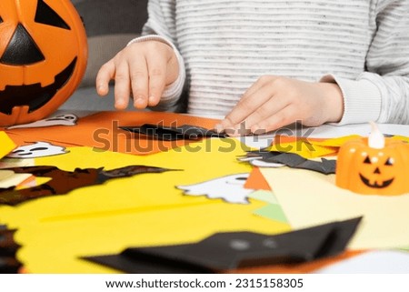 Preschool child creates Halloween origami paper bat crafts, close-up hands Royalty-Free Stock Photo #2315158305