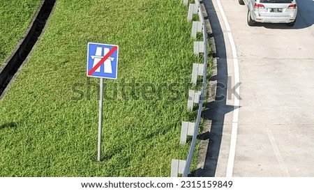 High angle view of a road sign end of highway autobahn and a passing car.