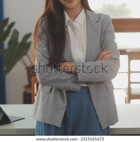 Portrait of Young Asian woman hand freelancer is working her job on computer tablet in modern office. Doing accounting analysis report real estate investment data, Financial and tax systems concept.
