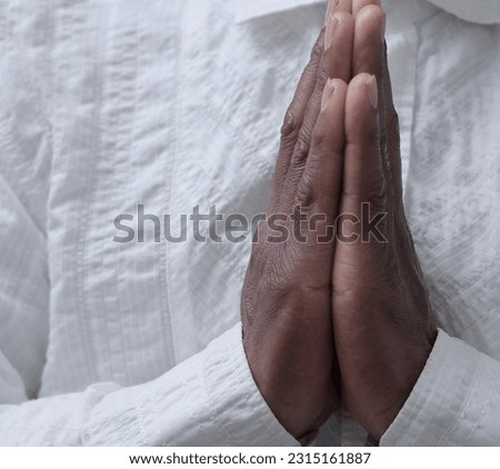 black man praying to god with hands together Caribbean man praying with grey black background stock image stock photo