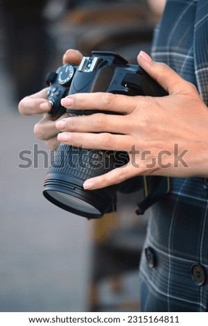 Girl photographer in her hands holds a professional camera