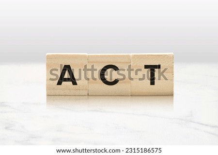 Three wooden tiles spelling ACT against a classy white marble background. Royalty-Free Stock Photo #2315186575