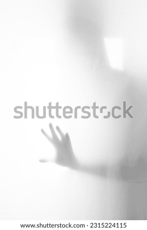 Hand shadow behind curtain. Mist
