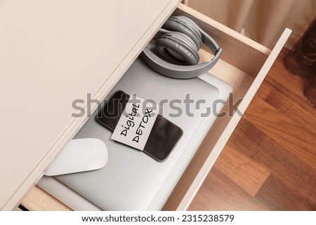 Digital gadgets are in separate desk drawer. Stop using digital gadgets at home. Digital detox, technology and social media addiction concept Royalty-Free Stock Photo #2315238579