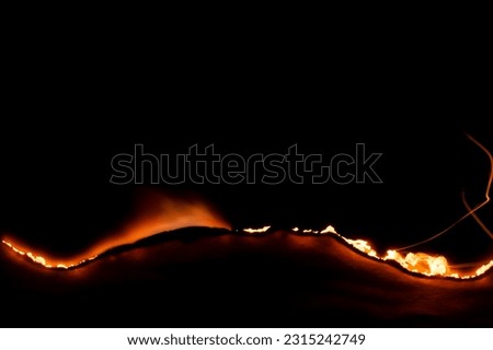 burning paper, glowing edge of paper on a black background Royalty-Free Stock Photo #2315242749