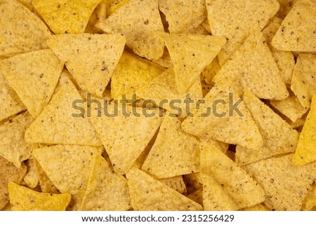 Background of Corn Tortilla Chips or Nachos. Tasty Mexican nachos chips as background, closeup Royalty-Free Stock Photo #2315256429