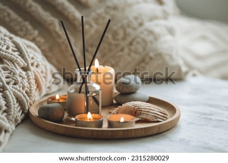 Cozy corner for home meditation and relaxation. Aroma diffuser, burning candles, stones for comfort, pleasure, aromatherapy. Decor for apartment, house, indoors design Royalty-Free Stock Photo #2315280029