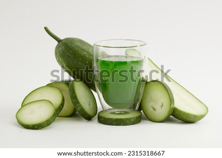 Against the white background, a glass of juice surround by winter melon slices. Scene for advertising drinking product with winter melon ingredient. Winter melon helps to lose weight extremely well. Royalty-Free Stock Photo #2315318667