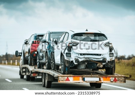 Tow truck with a broken car on a country road. Tow truck transporting car on the highway. Car service transportation concept. Roadside Rescue. Royalty-Free Stock Photo #2315338975