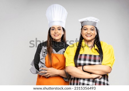 Indian female chef giving happy expression on white background.