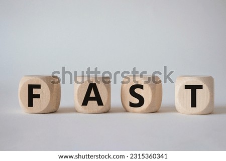 Fast symbol. Concept word Fast on wooden cubes. Beautiful white background. Business and Fast concept. Copy space.