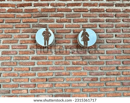 Restroom sign with brick wallpaper.  outdoor male and female toilet with brown background. WC Concepts