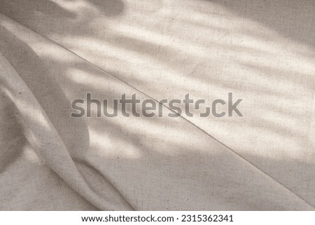 Aesthetic neutral beige linen texture background with a soft abstract sunlight shadows and folds Royalty-Free Stock Photo #2315362341