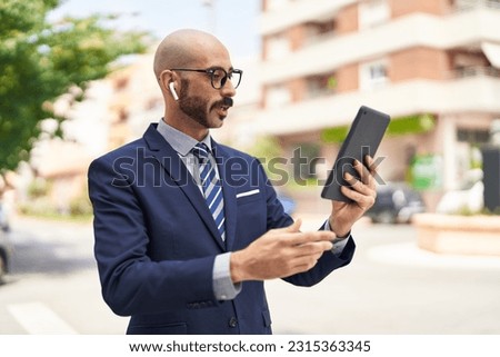 Young hispanic man executive having video call at street