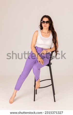 Fashionable young woman posing on chair Royalty-Free Stock Photo #2315371327