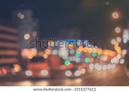 Urban street night traffic with bokeh lights, auto with brake lights, city street lights and speed. Toned abstract blurred background. Selective soft focus