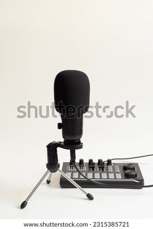 Selective focus shot of condenser microphone and audio interface isolated on white background. The focus is on microphone. 