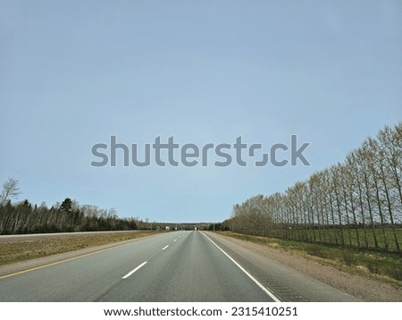 A large divided highway under a blue sky on a spring day.
