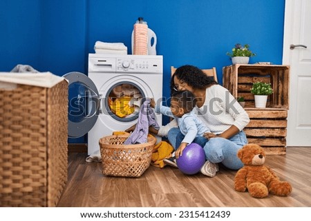Mother and son smiling confident washing clothes at laundry room