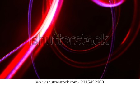 Long exposure light painting photography, abstract background, curvy lines of vibrant neon metallic in various colors against a black background