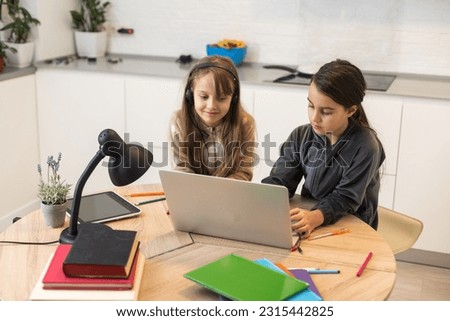 Two beautiful girls study at home