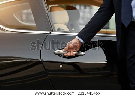 Businessman, hands and chauffeur by car door for travel accommodation, designated driver or commute. Hand of male person on vehicle handle in professional transport service, business class or pick up Royalty-Free Stock Photo #2315443469