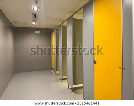 Row of public toilet decorated with wooden yellow door Royalty-Free Stock Photo #2315461441