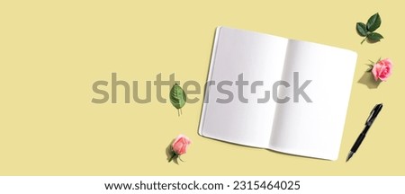 Open notebook or diary with a pen from above with rose buds- flat lay