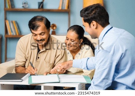Indian banker taking signature from senior man while with wife at home for documents - conept of financial advisor, realtor deal and satisfied customer
