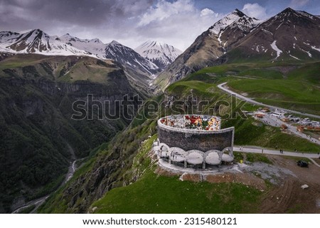 Aerial view of Russia–Georgia Friendship Monument located on the Georgian Military Highway between the ski resort town of Gudauri and the Jvari pass, overlooking the Devil's Valley in the Caucasus. Royalty-Free Stock Photo #2315480121