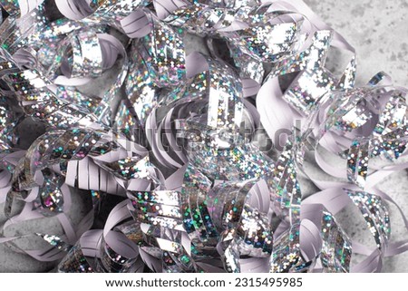 Holographic silver tinsel on a dark background