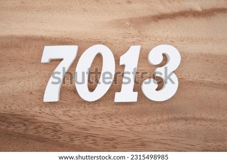 White number 7013 on a brown and light brown wooden background.