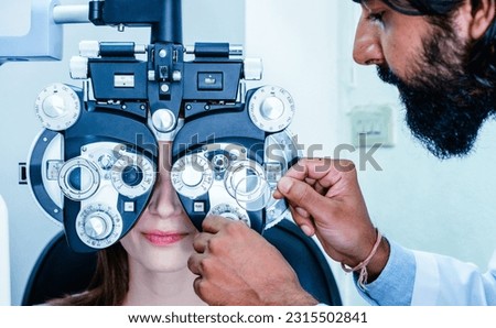 Man optometrist checking young woman's eyesight in clinic. Health care concept. Royalty-Free Stock Photo #2315502841