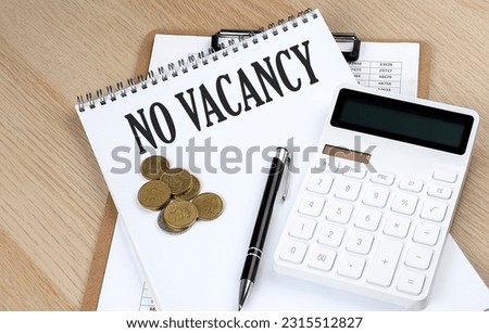 NO VACANCY text on notebook with chart and calculator and coins, business concept