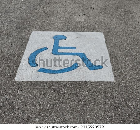 A close view of the painted handicap sign on the pavement.